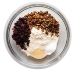 overhead photo of bread dough ingredients in a glass bowl