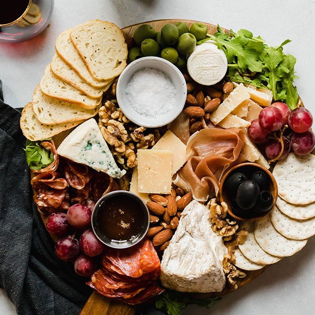 cheese plate with crackers, fruit, and spreads