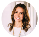 Woman smiling in front of white curtains
